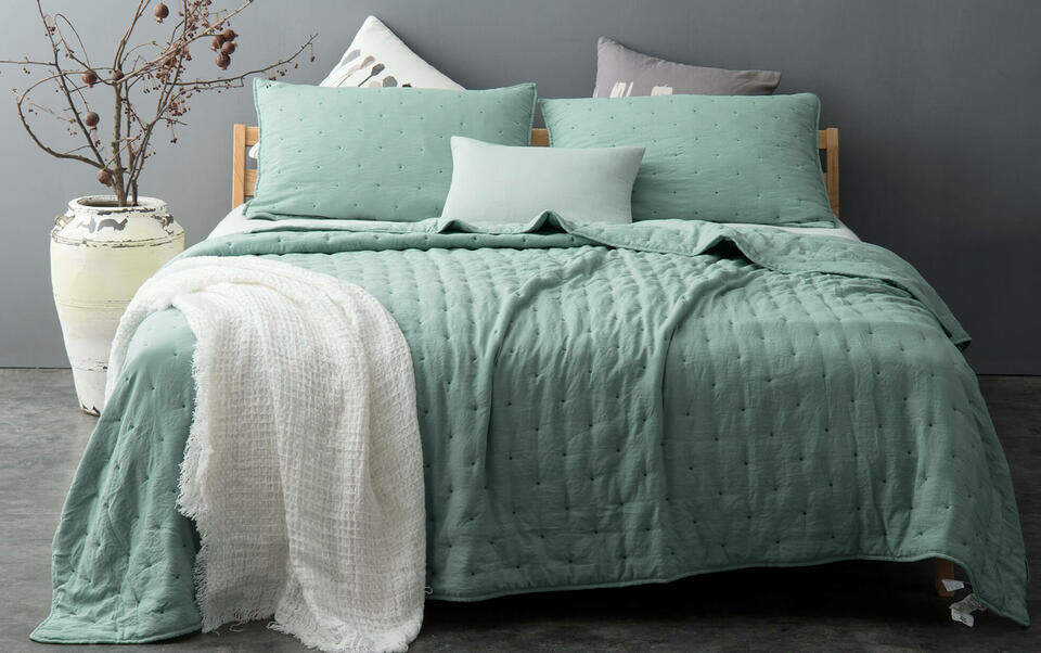 cama con colcha verde agua